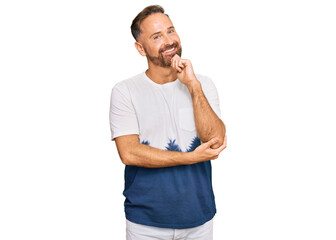 Fototapeta premium Handsome middle age man wearing casual tie dye tshirt looking confident at the camera with smile with crossed arms and hand raised on chin. thinking positive.