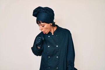 Beautiful brunettte woman wearing professional cook uniform feeling unwell and coughing as symptom for cold or bronchitis. health care concept.