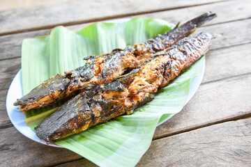catfish roasted on banana leaf - cooked catfish grilled Asian food on wooden table