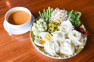 Thai rice noodles - Close up Thailand food vermicelli noodle boiled eggs and fresh vegetables on plate with curry soup bowl served wooden table