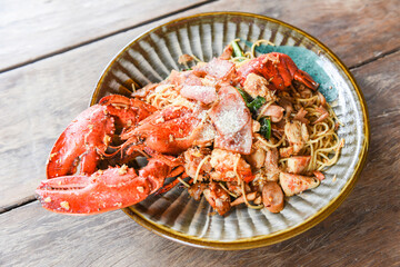 Grilled Lobster sausage ham vegetables and cheese spaghetti seafood on wooden table - Shellfish seafood plate with lobster dinner food cooked