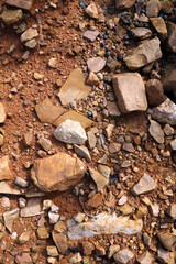 Wet ground, yellow soil, there are many small stones, details of the texture
