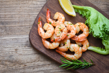 Seafood shelfish with rosemary lemon and lettuce - Salad shrimp grilled delicious seasoning spices on wooden cutting board background appetizing cooked shrimps baked prawns