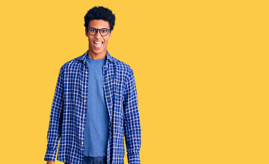 Fototapeta na wymiar Young african american man wearing casual clothes and glasses sticking tongue out happy with funny expression. emotion concept.