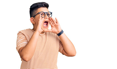 Little boy kid wearing casual clothes and glasses shouting angry out loud with hands over mouth