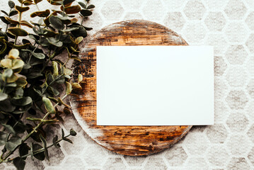 Photo of blank white card on a dark wooden cutting board circle. Blank template for brand identity mock-up design, food theme. Presentation and portfolio template