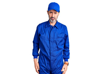 Middle age handsome man wearing mechanic uniform depressed and worry for distress, crying angry and afraid. sad expression.