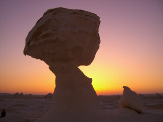 Fototapeta na wymiar Weird Shaped Rocks with the setting sun in the White Desert, Egypt