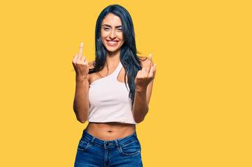 Beautiful hispanic woman wearing casual clothes showing middle finger doing fuck you bad expression, provocation and rude attitude. screaming excited