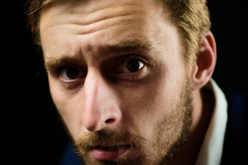 Fototapeta premium Close up studio shot of young man looking at the camera. Handsome guy with confident face.