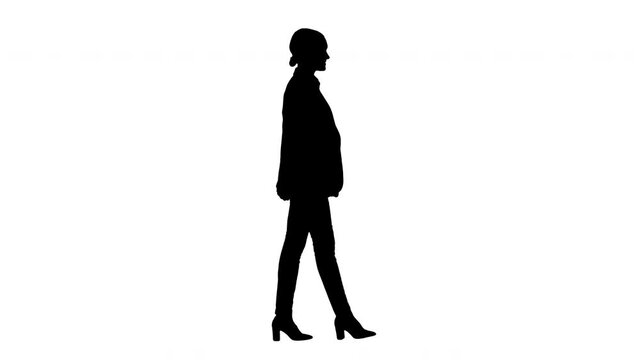 Silhouette Confident Businesswoman walking towards looking at camera with a smile.