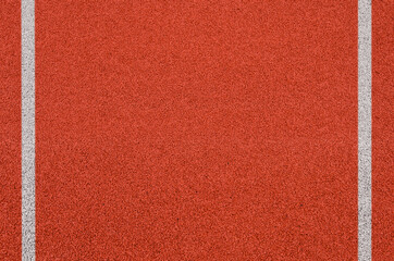 Fototapeta premium Top view of the running track rubber lanes cover texture with white line marking for background.