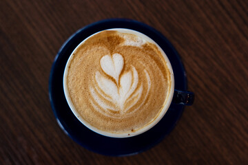 Close up image of Latte art with wooden background.
