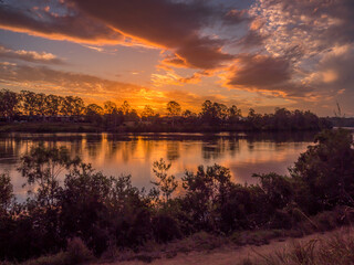 Obraz premium Beautiful Riverside Sunset with Reflections