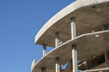 Geometric shape made of concrete on a background of blue sky.