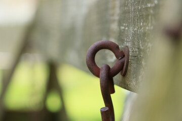 Rusty screw eye with chain and wood