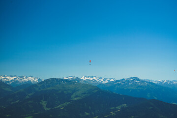 Gleitschirmflieger über den Tiroler Alpen im Sommer. Im Hintergrund die österreichischen Hochalpen