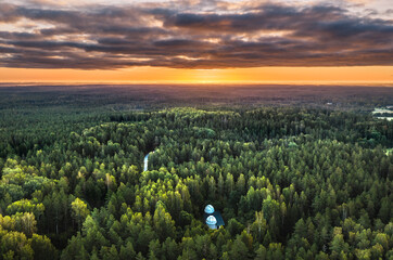 Fototapeta na wymiar Aerial view of sunrise over a pine forest with lake. Foggy and colorful morning in countryside.