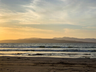 Fototapeta na wymiar Sunset in Paracas, bay and natural reserve of Ica in Peru. Sea, water, birds, dock, stones.