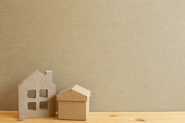 House model on wooden table with brown background. Real estate concept. copy space