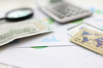 On table american dollars plastic cards and calculator and magnifying glass. Financial Empowerment Concept