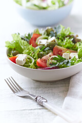 Salad with Green Olives, Tomatoes and Feta Cheese. Bright wooden background.	
