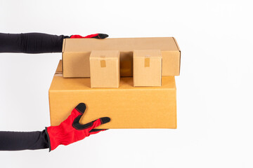 Several boxes in hands of courier. Courier hands close up. Concept - delivery of goods by courier service. Unlabeled boxes white background. Deliverymanhands over order. Delivery from online store