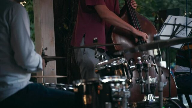 Close-up shot of a jazz band at a street concert. Live performance of a group of double bass and drummer.