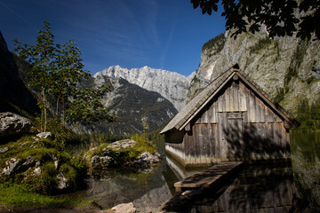 Bootshaus an klarem blauen See in den Alpen