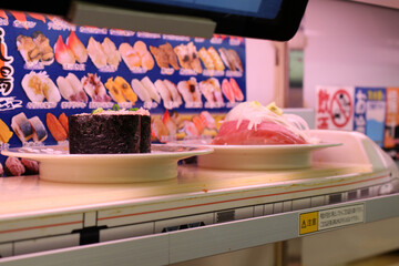 Sushi train runs along the rail at sushi shop