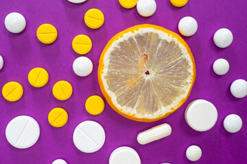 Vitamins. Pills and a slice of lemon. The fight against vitamin deficiency. Artificial and natural vitamins. Maintenance of immunity. Healthcare.