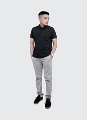 Fototapeta premium Full body shot of Handsome man wearing black polo shirt posing at plain background