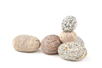 Sea smooth oval pebbles isolated on white background. Heap of stacked round pebbles.