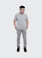 Full shot of Handsome man wearing grey polo shirt posing at plain background