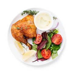 Baked chicken leg, served with sauce and fresh green salad. isolated on white background