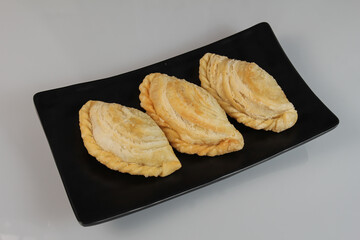 Curry Puff. South east Asia origin food concept homemade chicken Curry puffs on white plate and black background 
