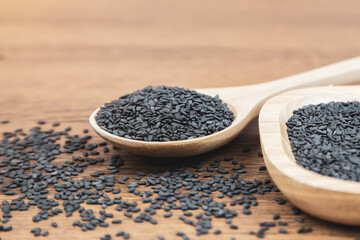 Black sesame seeds in a wooden spoon For healthy food and diet concepts.