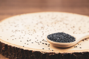 Black sesame seeds in a wooden spoon For healthy food and diet concepts.