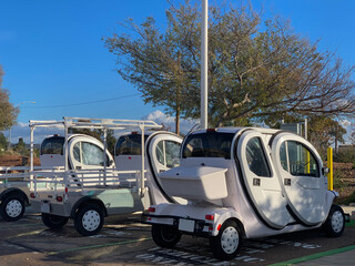Modern utility carts parked at charging station.