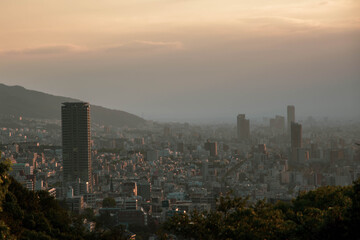 明け方神戸の山手諏訪山公園ヴィーナスブリッジより神戸市街を望む。朝靄に包まれて高層ビルが幻想的。