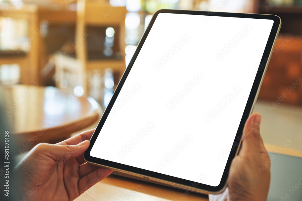 Wall mural mockup image of a woman holding digital tablet with blank white desktop screen