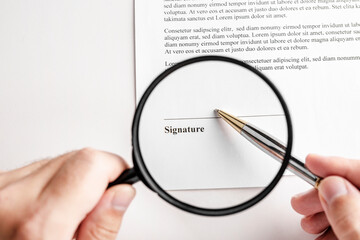 Businessman holding magnifying glass zoom and analyzing contract