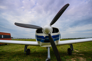 small single-engine civil airplane on a green grass of a countryside airdrome