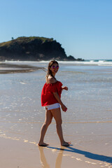 A young beautiful woman walking at the sandy beach