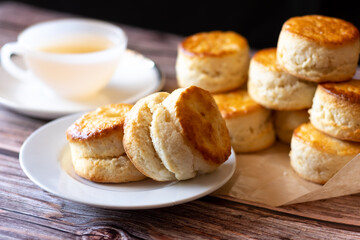 Obraz na płótnie Canvas Close up group of fresh yummy tasty delicious Traditional British Scones and a cup of tea on wooden table background. 