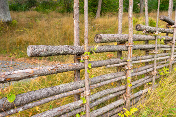 Old traditional swedish wooden fence. Countryside authentic cozy hand made wooden fence palisade in a rural area.