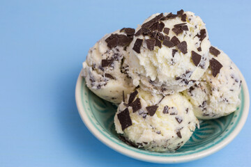 fresh stracciatella ice cream scoops with flakes of dark chocolate in a bowl