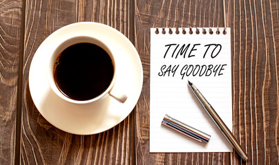 TIME TO SY GOODBYE - white paper with pen and coffee on wooden background