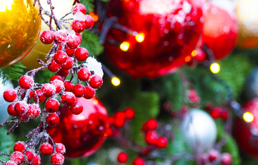 Christmas holiday decoration background, close-up. Festive beads, red berries, xmas tree balls toys...