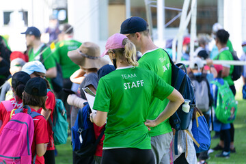 Team staff who standing  to watch document amid the children. Rear view.